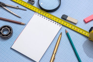 boş not defteri, kalem, cetvel ve grafik kağıt üzerinde pusula