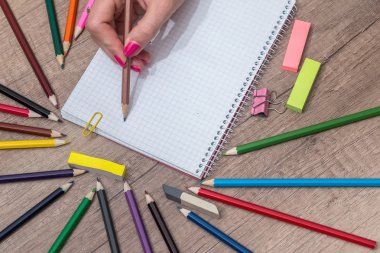 Ahşap masa üzerinde renkli kalemler ile boş kayda göre çizim kız