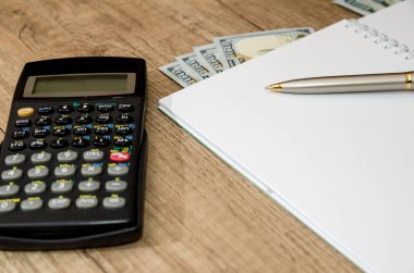 Hesap makinesi, bize dolar, defter kalem üstünde okul sırası ile