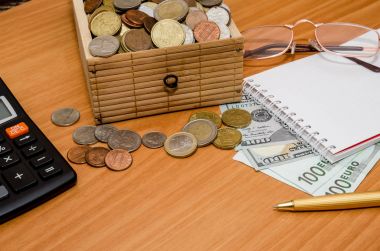 Hazine sandığı madeni para ile açın. Bize dolar ve euro boş not defteri, gözlük ve hesap makinesi