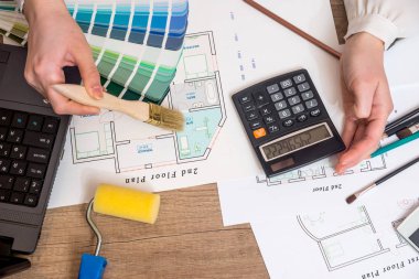 Dizüstü bilgisayar ile bir inşaat projesi çizimi mimar, renk paleti ve çalışma araçları