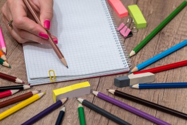 Ahşap masa üzerinde renkli kalemler ile boş kayda göre çizim kız