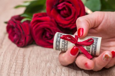 kırmızı gül bir arka plan üzerinde dolar tutan kadın
