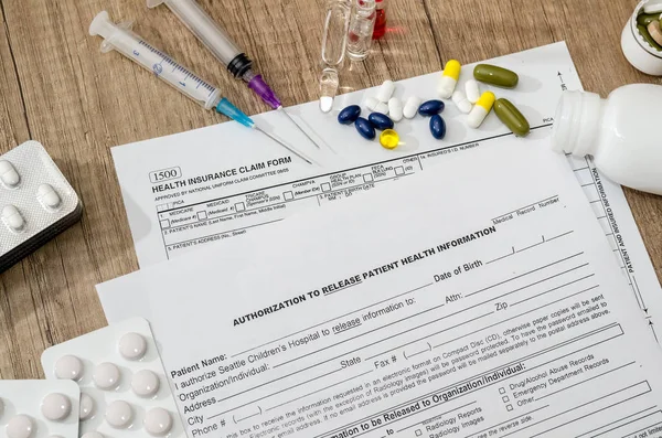 Medical patient form with pills and  syringes on  table