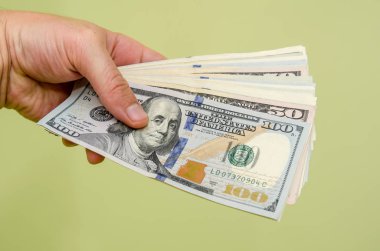 para yeşil arka plan üzerinde izole dolar tutan adam el