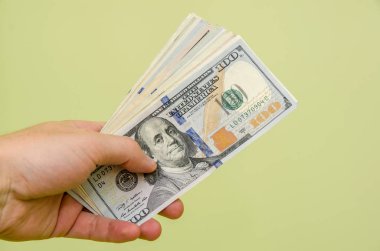 para yeşil arka plan üzerinde izole dolar tutan adam el