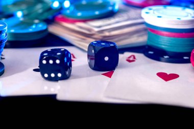 Siyah arka plan ile poker fişleri, kartlar, dolar ve kemikler