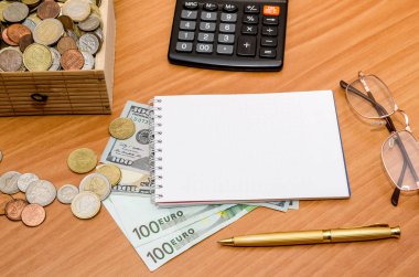 Hazine sandığı madeni para ile açın. Bize dolar ve euro boş not defteri, gözlük ve hesap makinesi