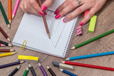 Ahşap masa üzerinde renkli kalemler ile boş kayda göre çizim kız