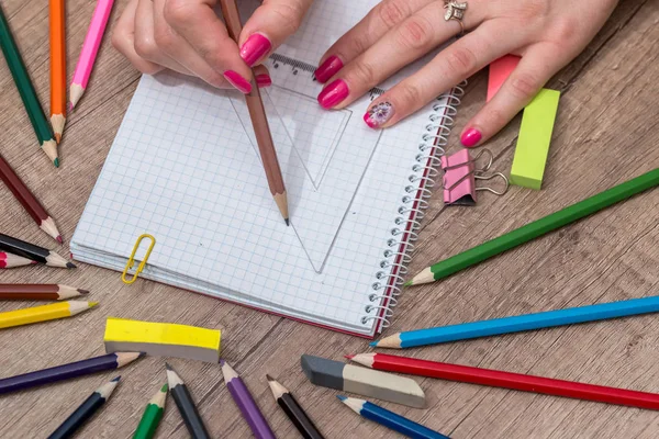 Ahşap masa üzerinde renkli kalemler ile boş kayda göre çizim kız