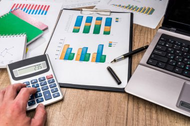 Dizüstü bilgisayar, hesap makinesi, Masa kalemi ile mali grafikler.