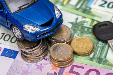 Mavi oyuncak araba anahtarı, euro Bono ve madeni para ile.