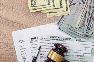 1040 vergi formu, tokmak ve dolar ve kalem.