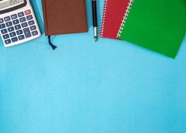 defter, hesap makinesi ve üzerinde mavi arka plan izole kalem