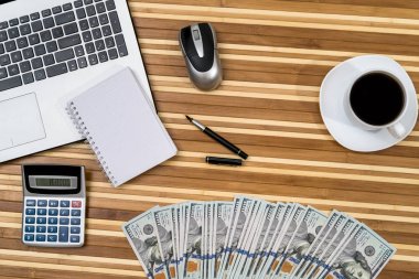 Çalışma masaüstü kavramı - dizüstü bilgisayar, para, kalem, kahve ve hesap makinesi