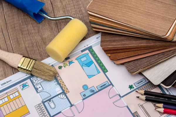 individual plan of house with wooden samples, pencil on desk.