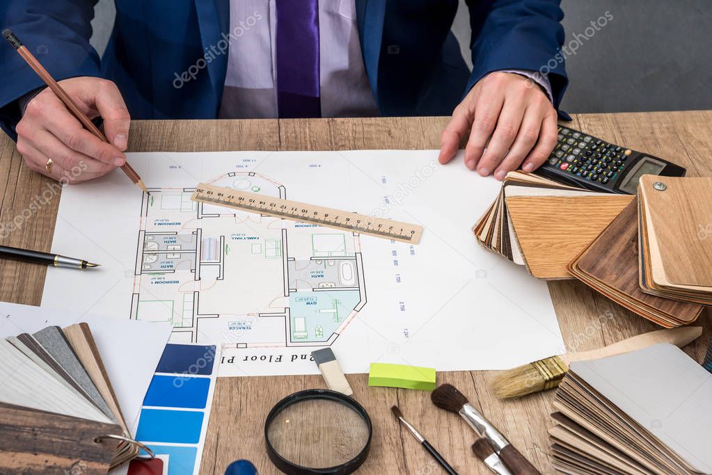 designer working with architect sketching construction project on wooden table