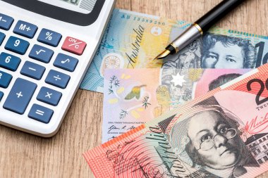 Ahşap bir masa Avustralya Doları hesap makinesi