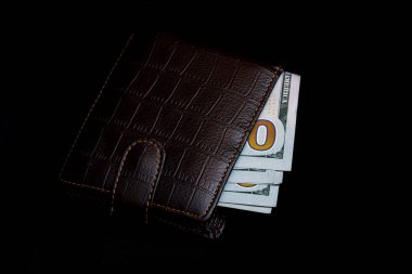 Yüz dolar faturaları koyu deri çanta siyah arka plan üzerine izole içinde