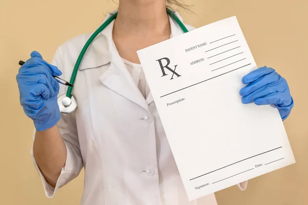 female doctor holding rx paper in hand