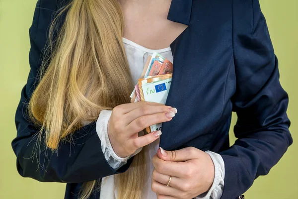 woman hides a pocket euro money isolated on green