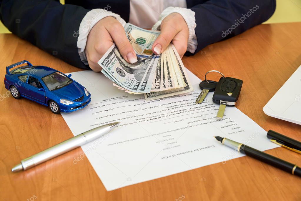 Male's hands signing on car contract claim form and calculator, dollar, car