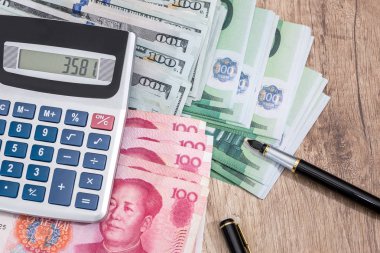Hesap makinesi ile Euro, dolalr ve yuan kalem üstünde okul sırası ile.