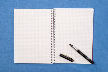 boş bir defter sayfalarında kalem yatıyor.