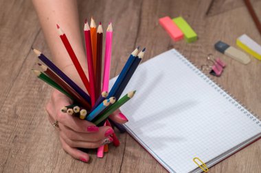 Ahşap masa üzerinde renkli kalemler ile boş kayda göre çizim kız