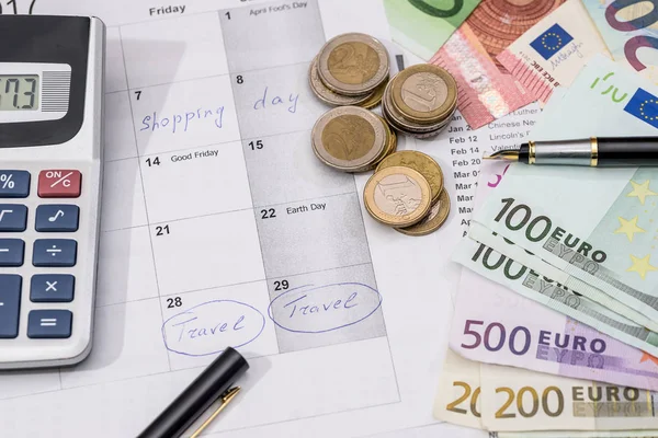 euro bills, calculator, ink pen and coin on calendar background - travel time