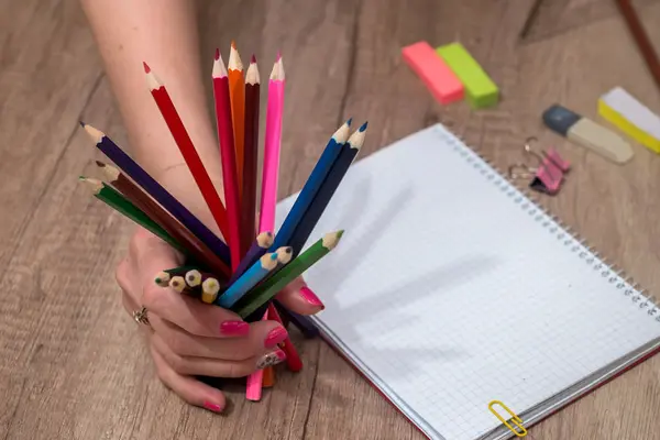 Ahşap masa üzerinde renkli kalemler ile boş kayda göre çizim kız