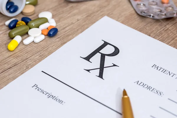 Medical prescription and drugs and pen on table