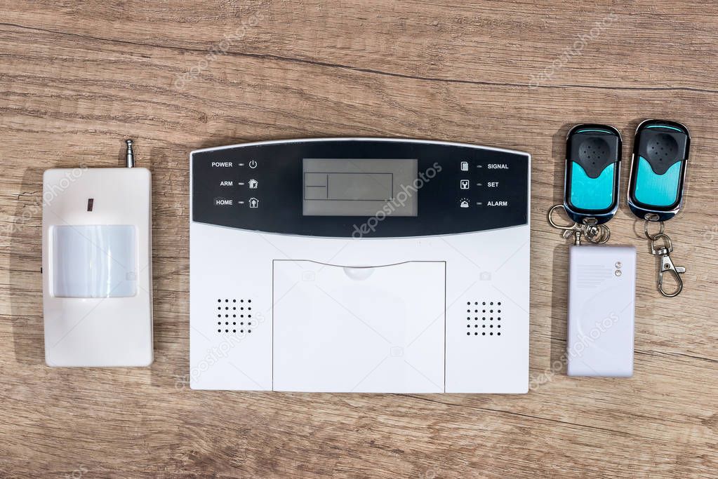 alarm system home on wooden desk.