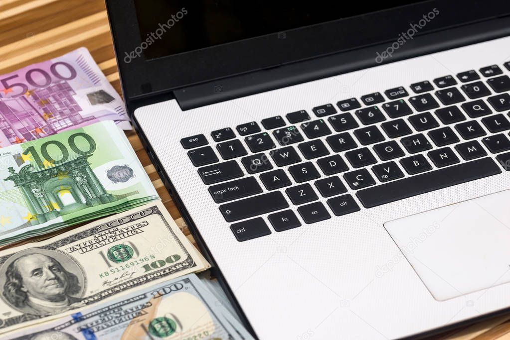 laptop with money on desk