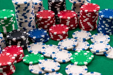 Poker kartları ve fişler yeşil masada.