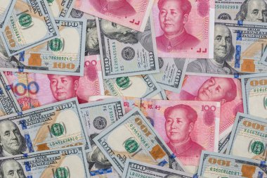 Chinese Yuan bills  vs  U.S. dollar as background . clipart