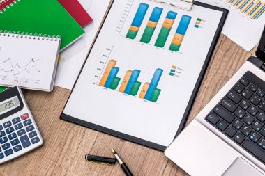 Dizüstü bilgisayar, hesap makinesi, Masa kalemi ile mali grafikler.