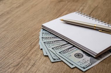 Amerikan yüz dolar ve kalem ve masa üzerinde boş Not