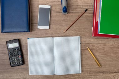 Hesap makinesi, not defterleri, kalem ve ahşap arka plan üzerinde akıllı telefon