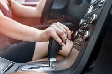 Kadın eli otomatik vites kutusunda, yakın plan.