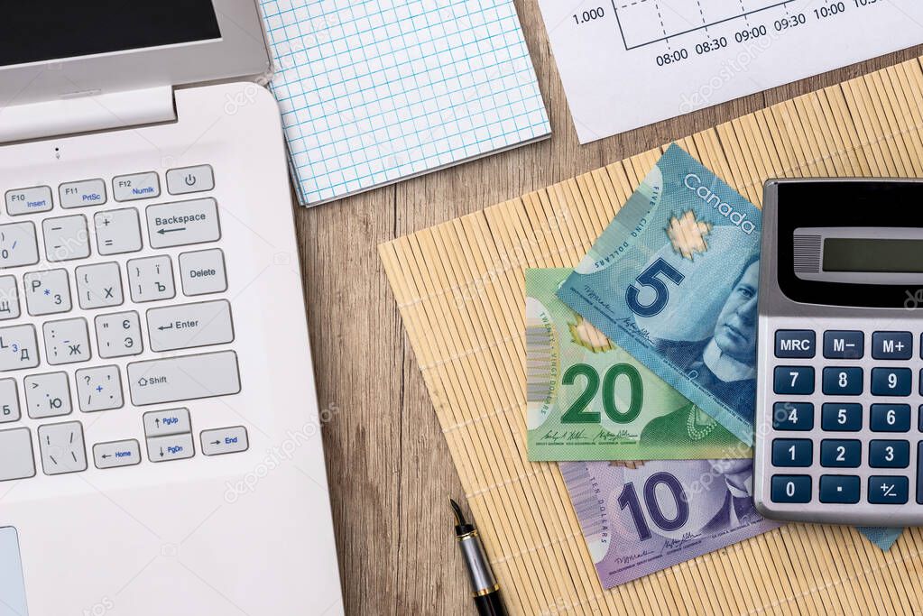 Canadian money with laptop, document, pan and calculator