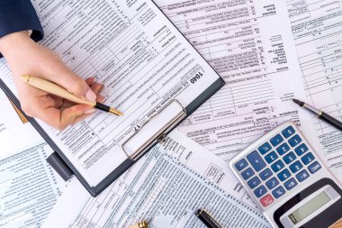 Kadın elinin üst görünümü 1040 formu dolduruyor