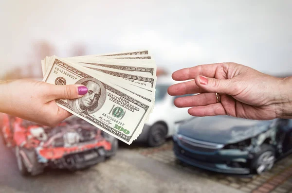 Macro foco em mãos femininas com dólar em cima do carro caiu — Fotografia de Stock