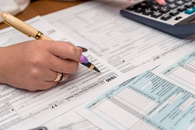 1040 vergi formunu dolduran dolma kalemli bir kadın.