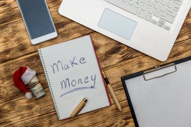 Dolar, dizüstü bilgisayar ve hesap makinesiyle 'Para Kazan' metni