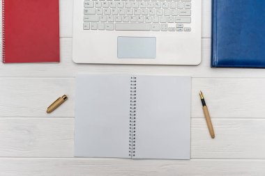 Boş kağıt ve kalem listesi olan dizüstü bilgisayar klavyesi