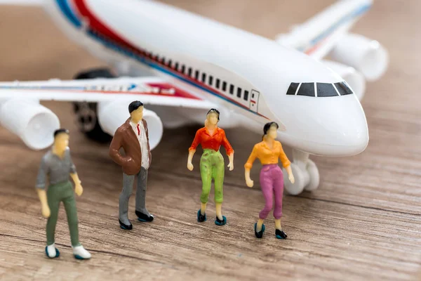 Miniature people go to airplane - travel concept
