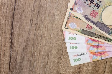 Chinese Yuan vs Japanese Yen on desk clipart