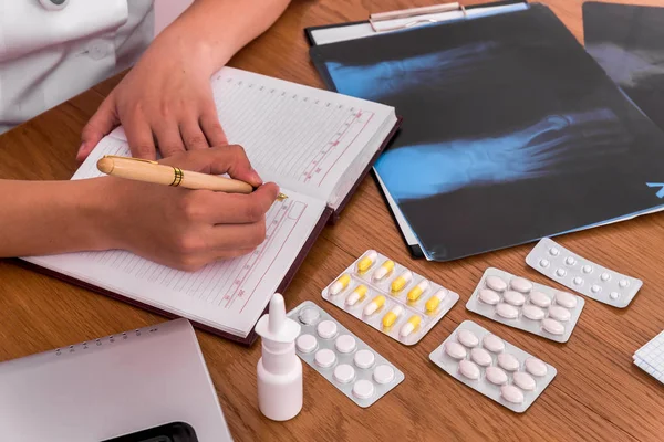 Doktor 'un elleri kalem ve defterle bazı notlar alacak.