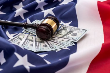 Amerikan bayrağına 100 dolarlık banknotlar ve bir çekiç. .